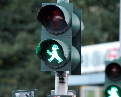 Grüne Fußgängerampel an einer Kreuzung, Wartungsarbeiten in Bielefeld angekündigt.
