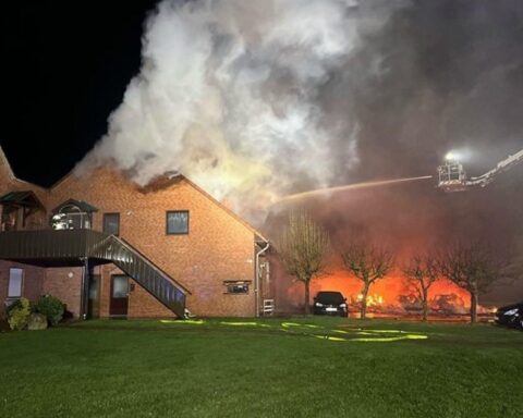 Nächtlicher Brand in Hille: brennende Autos und evakuiertes Mehrfamilienhaus. Feuerwehr im Einsatz.