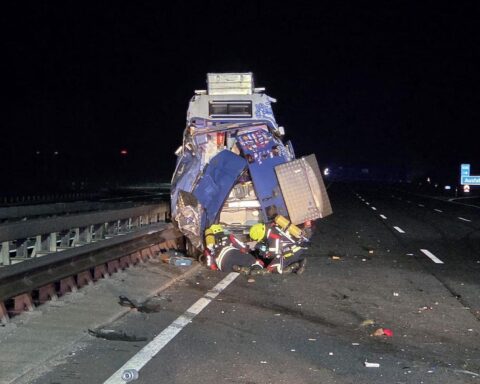 Feuerwehrkräfte in Schutzkleidung bei nächtlichem Einsatz nach Verkehrsunfall auf der Autobahn.