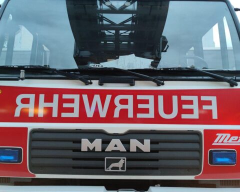 Feuerwehrfahrzeug im Einsatz bei einem Gebäudebrand in Kallstadt, Einsatzkräfte an der Arbeit.