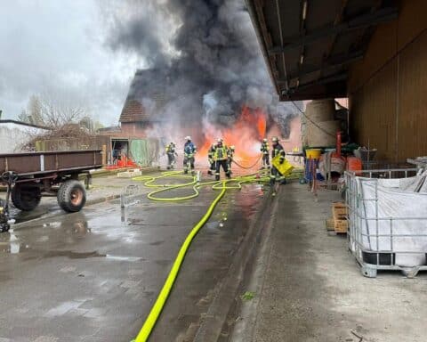 Großbrand in landwirtschaftlichem Betrieb, zerstörter Stall, Feuerwehr im Einsatz, Rauchwolken, betroffene Tiere.