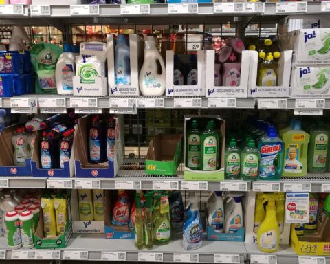 Reinigungsmittel mit Preisschildern, symbolisierende steigende Kosten durch geopolitische Einflüsse und Zuliefererpression.