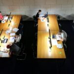 Studierende konzentriert beim Lesen und Arbeiten in einer modernen Bibliothek.