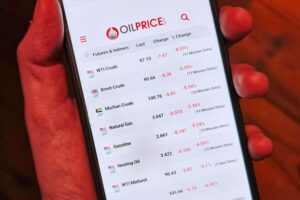 Grafik mit Ölpreisen auf Smartphone, symbolisiert globale Reaktion auf Krisen im Energiemarkt.