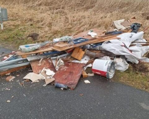 Müllhaufen mit Bauschutt und Abfall an Bahnseite, Ermittlungen der Polizei laufen.