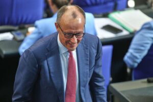 Friedrich Merz spricht bei einer politischen Veranstaltung, umgeben von Journalisten und Anhängern.