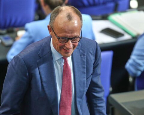 Friedrich Merz spricht bei einer politischen Veranstaltung, umgeben von Journalisten und Anhängern.