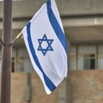 Israelische Flagge vor der Knesset, Symbol für aktuelle militärische Aktionen zum Schutz von Zivilisten.