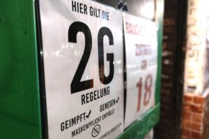 2G-Hinweisschild an einer Bar symbolisiert Corona-Maßnahmen und deren rechtliche Auseinandersetzungen.