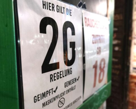 2G-Hinweisschild an einer Bar symbolisiert Corona-Maßnahmen und deren rechtliche Auseinandersetzungen.