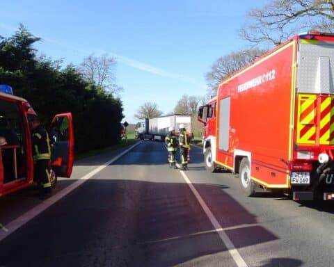 Kleintransporter liegt auf der Seite nach Unfall mit LKW; Feuerwehr am Einsatzort.