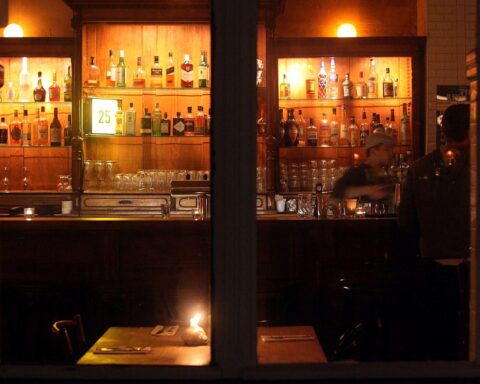 Zwei Freunde genießen ein Bier in einer gemütlichen Kneipe mit rustikaler Einrichtung.