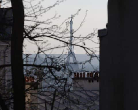 Eiffelturm, symbolisch für Paris, umgeben von Wahlurnen und politischen Symbolen der Kandidaten.