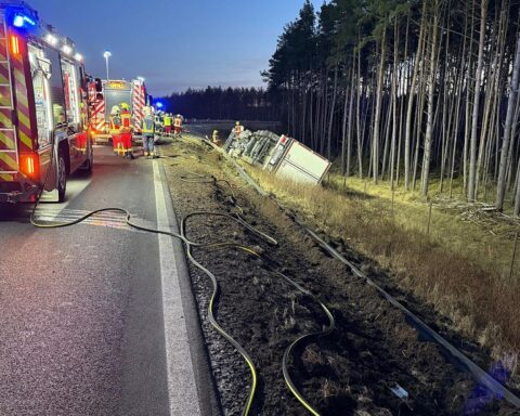 LKW-Unfall auf Autobahn: umgekippter Lastwagen im Graben, Feuerwehr rettet verletzten Fahrer.