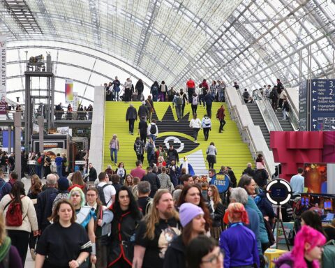 Bunte Buchstände und zahlreiche Besucher auf der Leipziger Buchmesse, Begeisterung und Publikumsandrang sichtbar.