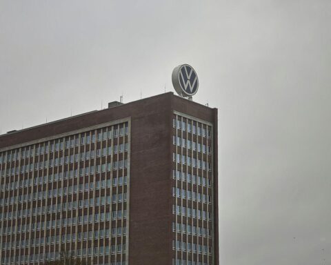 Volkswagen-Logo mit enttäuschten Mitarbeitern, die für gerechte Boni und Wertschätzung kämpfen.