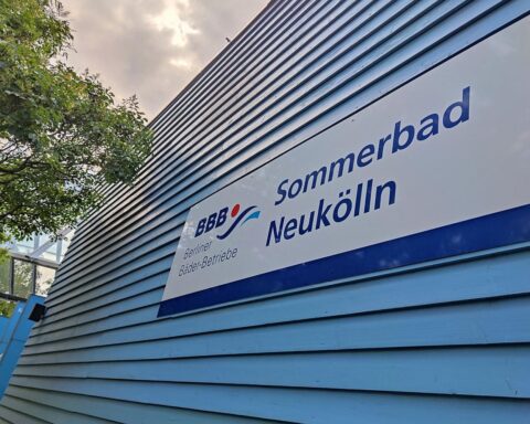 Ein Freibad mit Sonnenliegen und fröhlichen Besuchern im Wasser, symbolisiert Sommerfreude und Erholung.