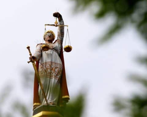 Politiker diskutieren umstrittene Öffnungszeitenverordnung; Justitia symbolisiert Gerechtigkeit und rechtliche Auseinandersetzung.