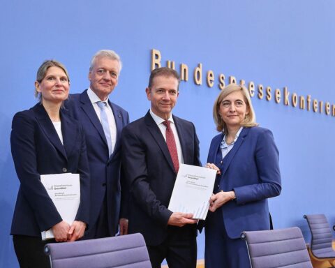 Protestierende Menschen halten Schilder gegen unfaire Krankenkassenreformen; Sören Pellmann spricht auf einer Veranstaltung.