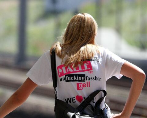 Eine fröhliche Mallorca-Touristin genießt die Atmosphäre eines Festivals unter blauen Himmel.