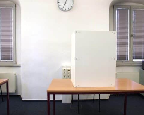 Wahllokal mit Wahlurnen und Bürgern, die an der Oberbürgermeisterwahl in Nürnberg teilnehmen.