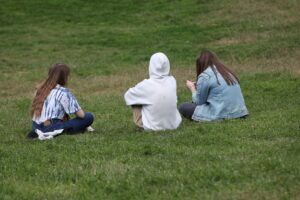 Drei junge Frauen im Park, symbolisieren respektvolle Beziehungen und Genderdiskriminierung in Deutschland.