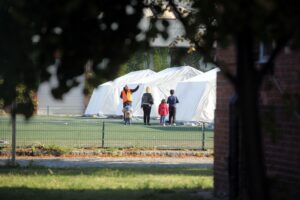 Flüchtlingsfamilie in einer Zeltstadt, die Unterstützung und Beratung benötigt.