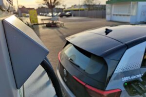 E-Auto-Ladestation vor Mehrparteienhäusern, symbolisiert den Ausbau nachhaltiger Ladeinfrastruktur in Deutschland.