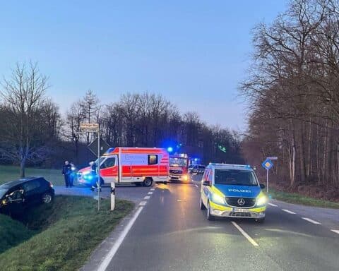 Ein Unfallauto im Graben, Polizei vor Ort, Krankenhauswagen, verletzter Fahrer.