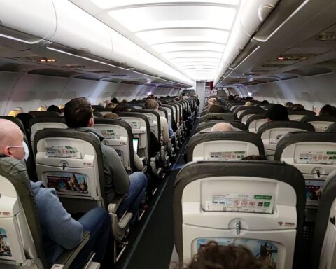 Passagiere warten am Flughafen, während Corona-Pandemie Flugstörungen und rechtliche Ansprüche thematisiert.