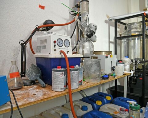 Zwei festgenommene Männer, Polizei sichert Drogenlabor und chemische Substanzen in Wohnung.