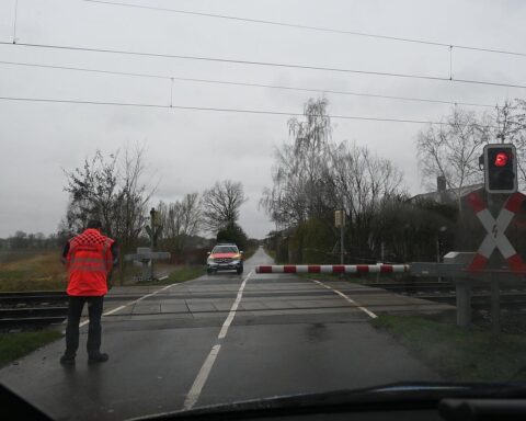 Beschädigte Bahnschranke am Unfallort, Polizei sucht flüchtigen Fahrer, Hinweisgeber gesucht.