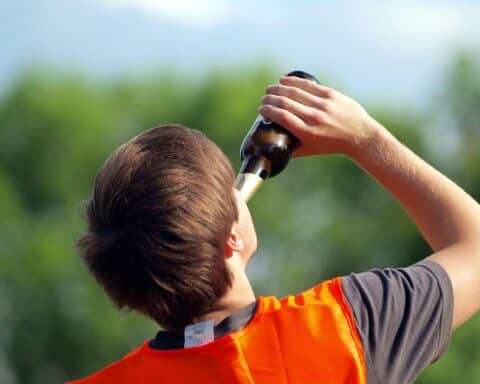 Mann trinkt Bier, symbolisiert Diskussion über Jugendschutzgesetz und Alkoholkonsum von Jugendlichen.