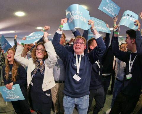 CDU-Vertreter feiern Wahlerfolg laut Prognosen, im Hintergrund Wahlurnen und jubelnde Unterstützer.