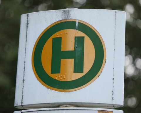 Busse an Bushaltestelle, symbolisieren Schienenersatzverkehr Hamburg-Berlin, Qualitätsprobleme und Pendlerunmut.