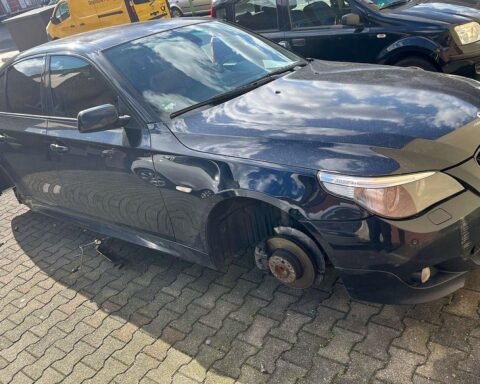 Ein aufgebockter BMW ohne Räder, daneben ein Rucksack mit Tatwerkzeug, Polizisten in der Nähe.