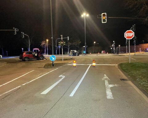 Zwei beschädigte Pkw am Unfallort, Einsatzkräfte versorgen verletzte Personen, Polizei ermittelt.