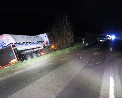 Lkw und VW Golf im Straßengraben nach Unfall; Feuerwehr rettet eingeklemmte Fahrerin.
