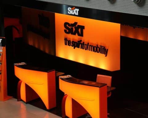 Ein Mietwagen, umgeben von Elektronik und einem Hinweis auf neue EU-Regulierungen.