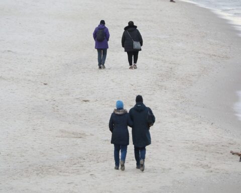 Paare am Strand symbolisieren die familiäre Gemeinschaft, die von Steuererleichterungen profitiert.