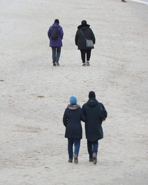 Paare am Strand symbolisieren die familiäre Gemeinschaft, die von Steuererleichterungen profitiert.