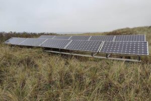 Solarzellen auf einem Dach, umgeben von Landschaft, symbolisieren den Anstieg erneuerbarer Energien in Deutschland.