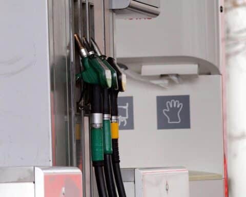 Tankstelle mit Warteschlangen und vollen Tanks, Kundschaft reagiert auf steigende Kraftstoffpreise.