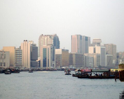 Dubai Skyline mit Wüste, Reisende, unsicheres Wetter: Symbol für Tourismus und geopolitische Spannungen.