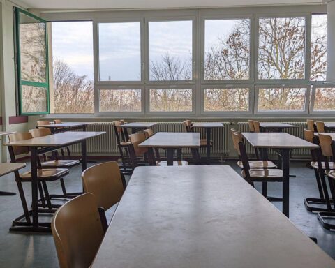 Leerer Klassenraum mit Tischen, Stühlen und Lehrmaterialien, symbolisiert Personalmangel an Förderschulen.