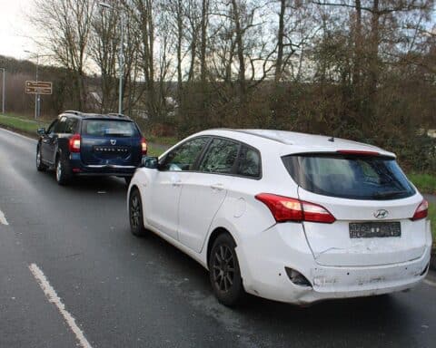 Unfallstelle mit drei beschädigten Fahrzeugen und Polizeipräsenz, nach Auffahrunfall in Hagen.