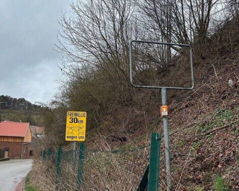 Ortsschild Rumbach, gestohlen und im Straßengraben liegend, Polizei sucht Zeugen.