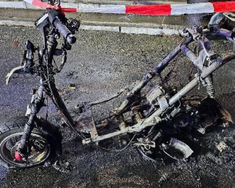 Motorradbrand auf Schulhof in Wolfsburg: zerstörtes Fahrzeug und Feuerwehr im Einsatz.