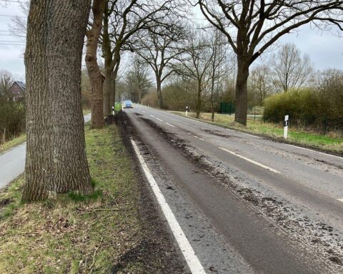 Unfallstelle mit beschädigter Straße und aufgewühltem Erdreich, Polizei sucht Zeugen.