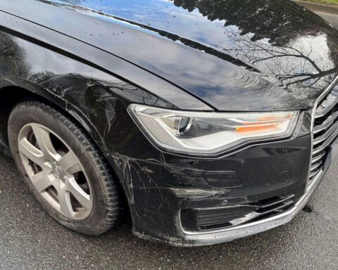 Unfallort mit stark beschädigtem Audi A6 Avant und Hinweisen zur Unfallflucht des Verursachers.